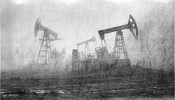 An old film black-and-white image of oil production in America USA. pumps rocking at dawn amid the damaged ecology of alpine meadows work to produce the energy of the modern world