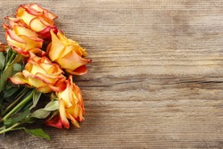 Orange roses on wooden background, copy space