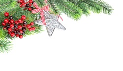 Christmas compositionon with green fir branches, red holly berries and silver star shaped christmas bauble are isolated on a white background, with space for texta white background
