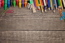 Crayons and pencils on wooden background
