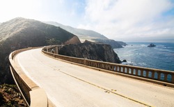 Highway between mountains and pacific ocean. Bixby Bridge at Big Sur 