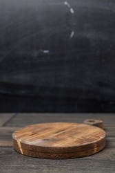 Empty vintage cutting board on dark wooden planks food background concept