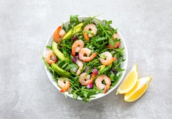 Shrimp arugula salad with avocado slices, high angle view of ready-to-eat keto-friendly dish, simple and healthy recipe