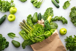 Green vegetables in a paper shopping bag, top-down view, sustainable living concept
