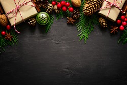 Christmas or New Year dark wooden background, Xmas black board framed with season decorations, space for a text, view from above