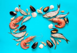 Sea food composition, flat lay of fishes, shrimps, shells and mussels, view from above, space for a text