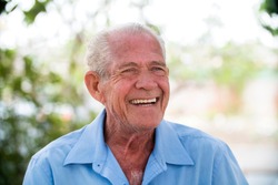 portrait of senior brazilian man looking at one spot in sunset and smiling. Horizontal shape, copy space.