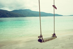Wooden swing on beautiful white sand tropical beach, Thailand. retro filter.