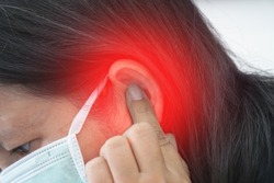 Tinnitus.female having ear pain touching painful head.