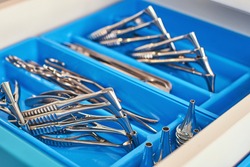 Otolaryngology medical instruments for ear, nose, throat, base of the skull treatment and surgery such as nasal speculums, forceps, tongue depressors, probes and tweezers in blue doctor box