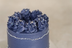 Beautiful festive cake biscuit with different creams. Wedding cake with flowers. Appetizing blue like ice a wedding cake decorated with large roses. Fancy wedding cake. Pastry dessert from above.