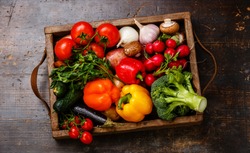 Fresh vegetables in wooden box on wooden background