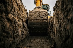 Cropped picture of an excavator digging hole on construction site.