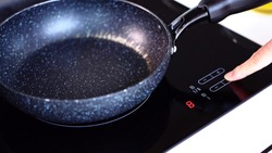 Frying pan on induction cooker in kitchen.