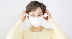 Middle-aged asian woman wearing facial mask. Prevent infection.