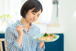 Young asian woman who is in trouble because she cannot eat meat dishes.
