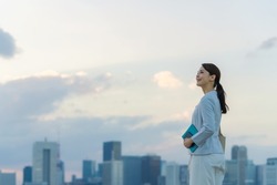 Young asian woman standing in front of the city.