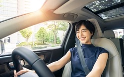 Young asian woman driving a car.