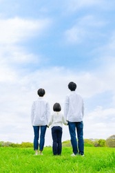 Asian family standing under blue sky. Environment concept. Childcare. Sustainable lifestyle.