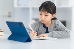 Asian little girl studying with a tablet PC.