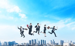 Group of businesspeople jumping in front of blue sky. Success of business.