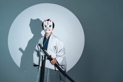 Child samurai wearing a fox mask. Japanese ninja character.