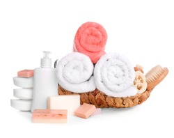 Basket with soft towels and toiletries on white background