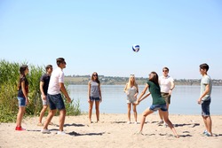 Group of friends playing volleyball at beach