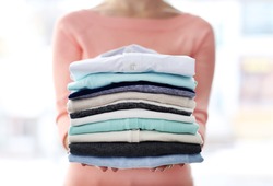 Woman hold clothes pile, close up