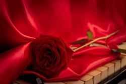 Red rose with red cloth on piano