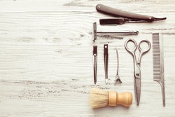 Vintage tools of barber shop on light wooden background