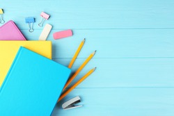 Colorful notebooks and office supplies on wooden background