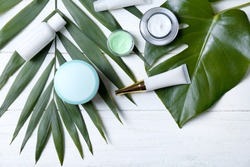 Natural cosmetics and leaves on table