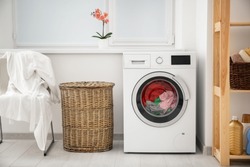 Laundry in washing machine and basket indoors