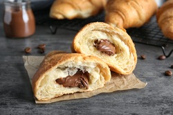 Yummy fresh croissant with chocolate on table