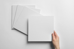 Woman holding blank sheet of paper on white background. Mock up for design