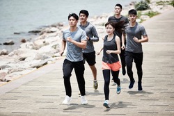 group of five young asian adult men and woman running training outdoors