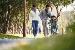 young asian family enjoying outdoor activity in city park