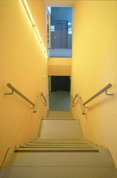 Yellow walls building interior with stairs and handrails. Nobody. Vertical