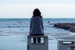 Girl alone looking at the sea
