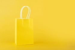 shopping bag on yellow background, copy space, monochrome,one color 