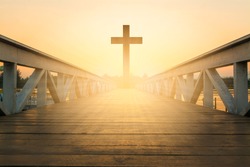 silhouette christian cross at railhead wooden bridge and orange sky with lighting,religion concept