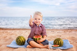 adorable baby eating watermelon on the beach