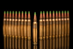 A group of 5.56 calibar, green tip bullets ordered into the lines on black background