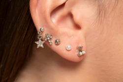 ear piercings photos.Helix piercing.Ear rings. Close up.