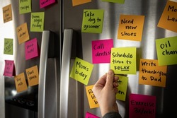 Hand Holding Schedule Time to Relax Sticky Note Memo to Fridge Door Full of Colorful Reminders
