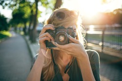 Hipster photographer using retro camera. Tourist girl capturing the moment

