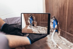 Handyman taking a photo of a damaged wall in the bathroom for insurance and verification purposes