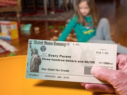 Mockup of US Treasury illustrative check for child tax credit for a small girl to illustrate American Rescue Plan Act of 2021 payments
