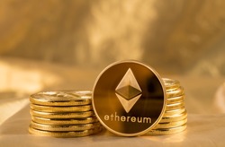 Stack of ether coins or ethereum on gold background to illustrate blockchain and cyber currency